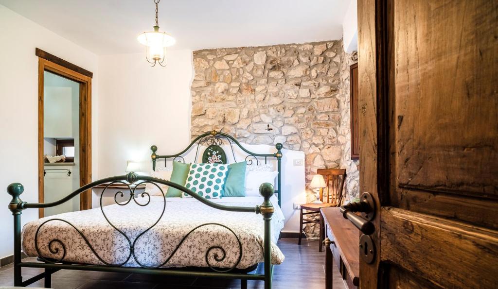 a bedroom with a bed and a stone wall at B&B Porta Soprana in Trentinara