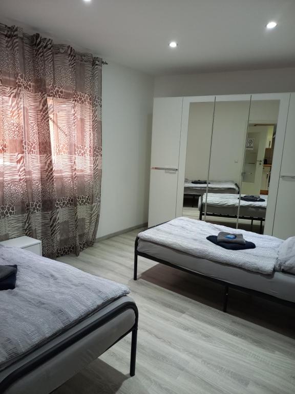 een slaapkamer met 2 bedden en een spiegel bij Monteurwohnung in Loiching