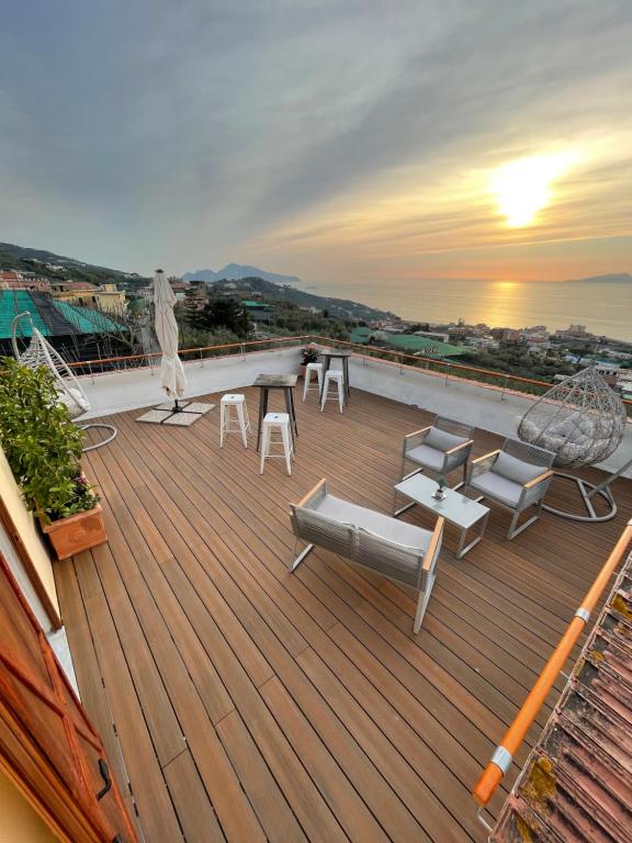 a rooftop deck with chairs and a table and the sunset at Il Chiostro in Massa Lubrense