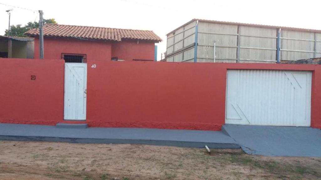 eine rote Wand mit zwei weißen Türen und einem Gebäude in der Unterkunft Casa Cantinho de Santarém in Santarém