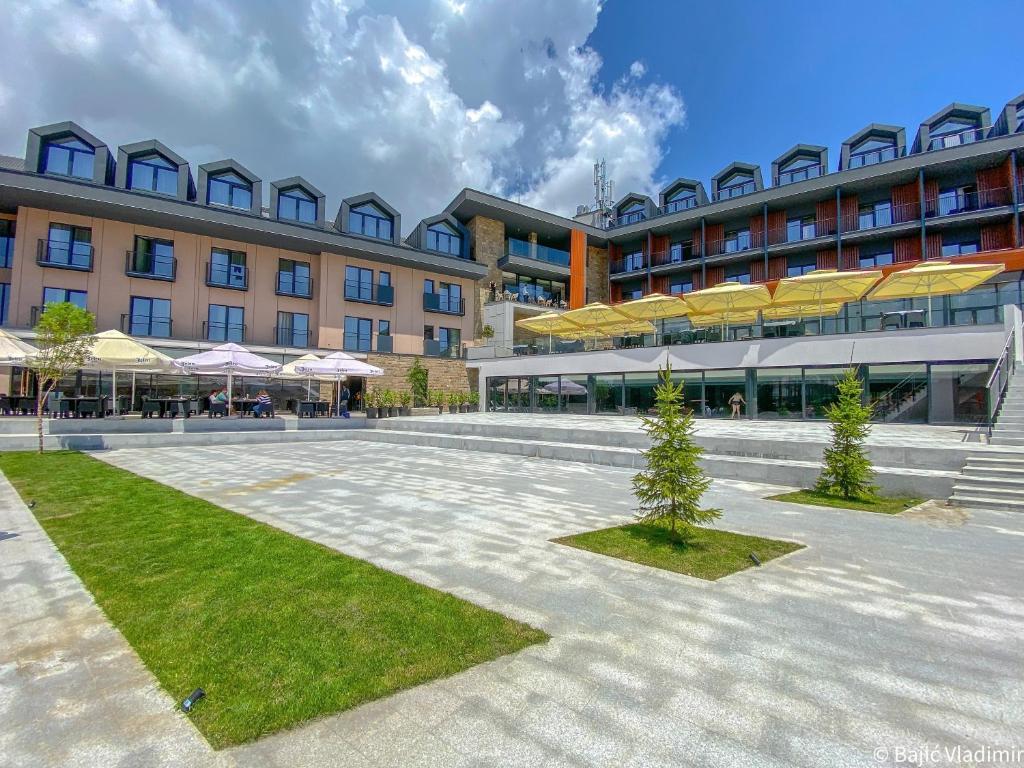 a large building with a courtyard in front of it at Hotel Crni Vrh in Divčibare