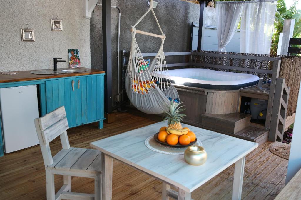 Habitación con mesa, hamaca y bañera. en Zapat Lodge en Baie-Mahault