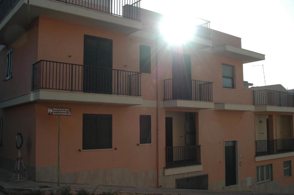um edifício de apartamentos com o sol a brilhar sobre ele em Casa Vacanze Antares em Portopalo