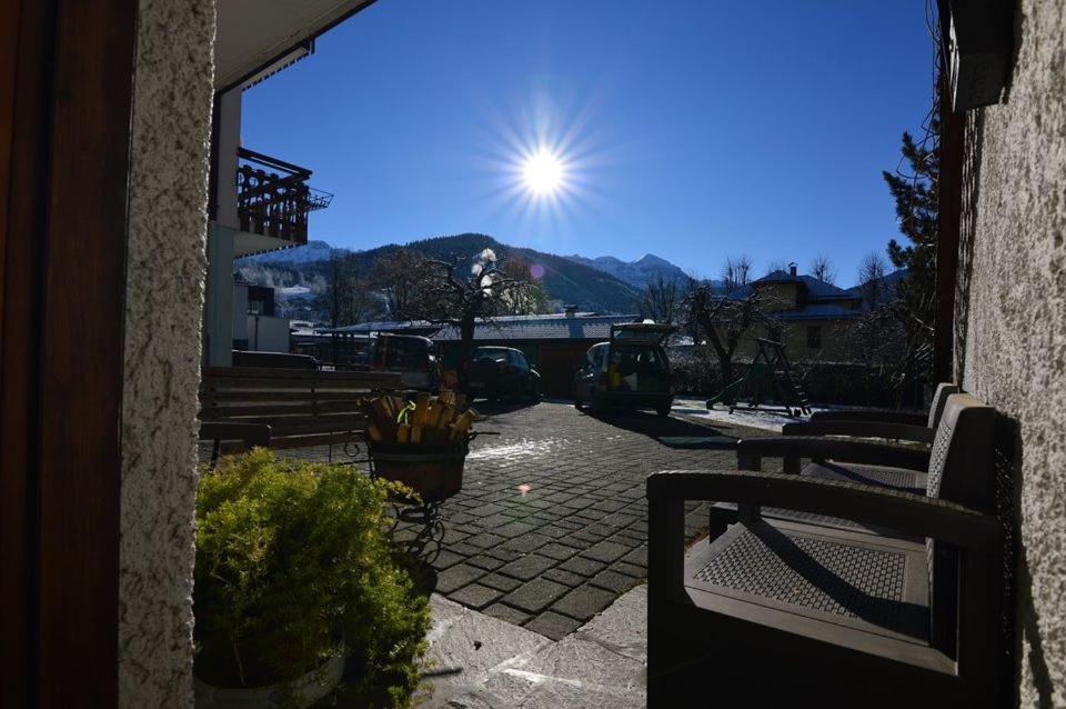 a view of a patio with benches and the sun at DOLOMITI house 1 in Fiera di Primiero