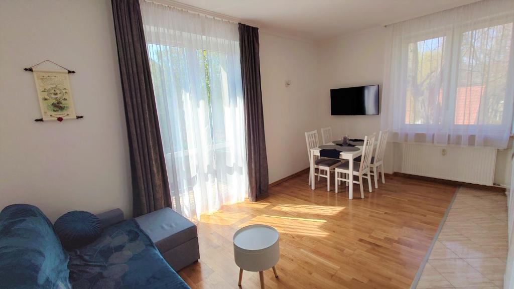 ein Wohnzimmer mit einem blauen Sofa und einem Tisch in der Unterkunft Apartament Amber in Sopot