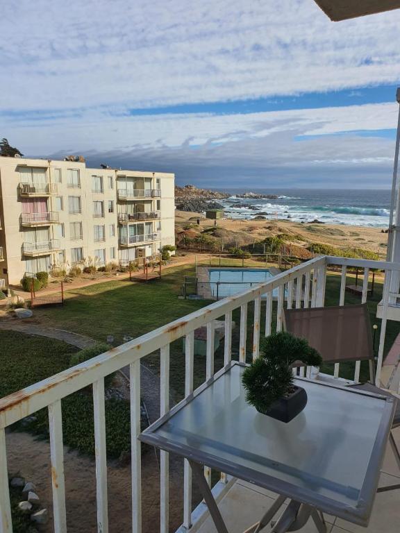 Un balcón con mesa y vista al mar. en Dpto Bordemar 2, en Las Cruces