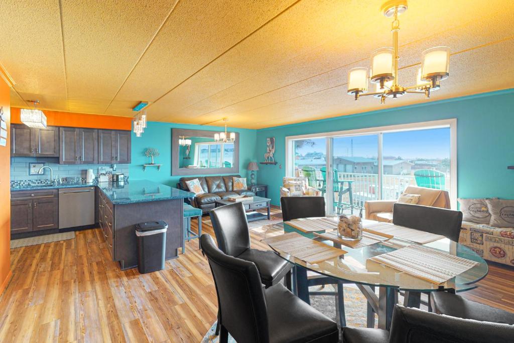 a dining room and kitchen with a table and chairs at Assateague House 205 in Ocean City