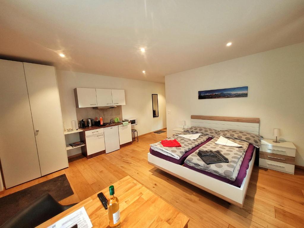 ein großes Schlafzimmer mit einem Bett und einer Küche in der Unterkunft Brunnematta in Ernen