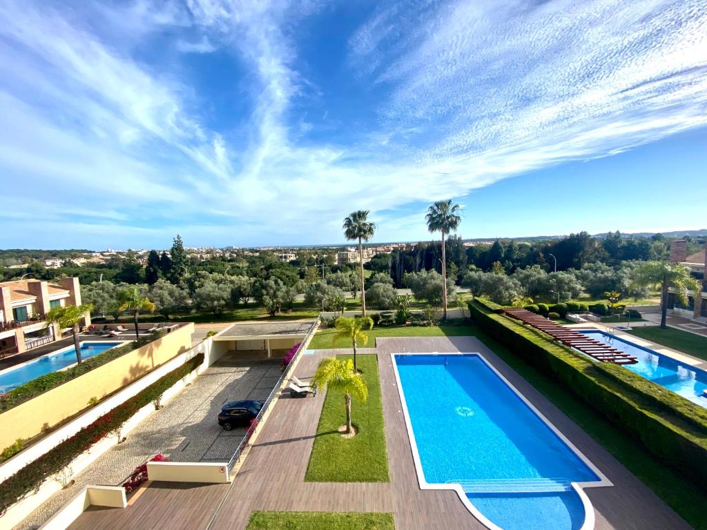 uma imagem de uma piscina no telhado de uma casa em Apartamento Vista Golfe Mar Vilamoura em Vilamoura