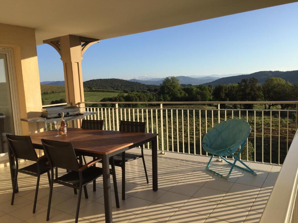 une table et des chaises sur un balcon avec vue dans l'établissement T3 Vignes & Terrasse 25 m2 au calme - Vue verdoyante - À 7 min de la plage - Parking Gratuit - La Croix-Valmer, à La Croix-Valmer