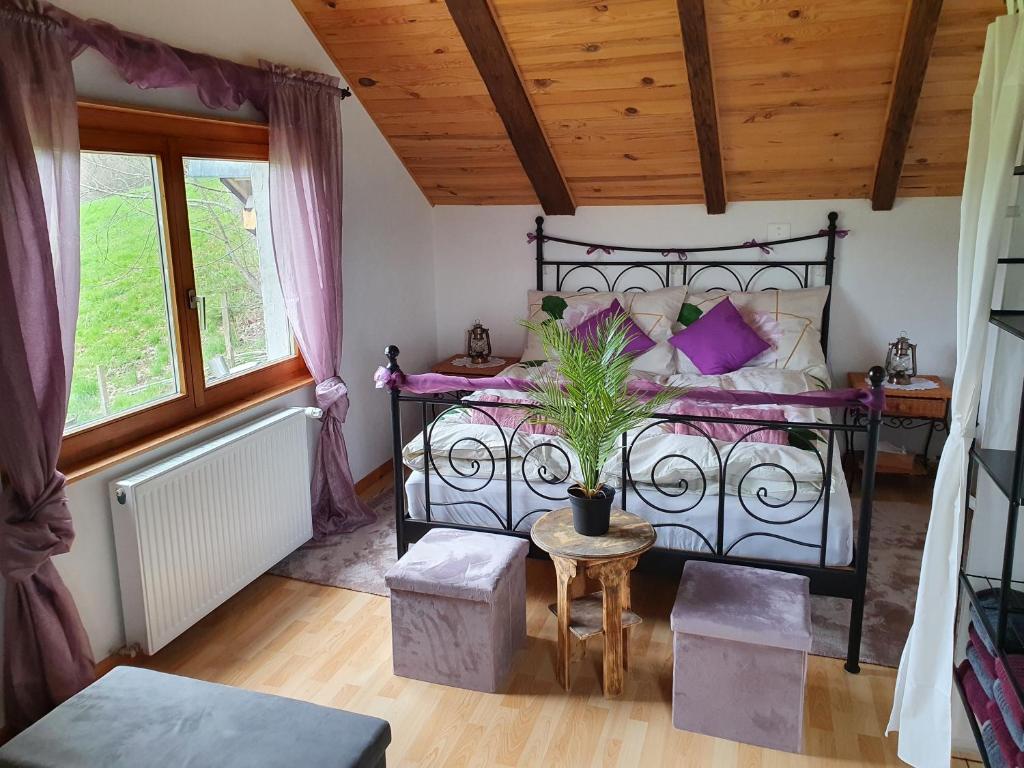 Un dormitorio con una cama negra con almohadas moradas en Gîte de la Motte, en Tavannes