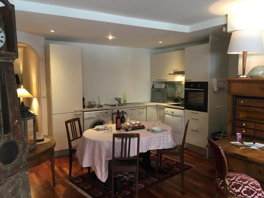 eine Küche mit einem Tisch und Stühlen im Zimmer in der Unterkunft Charmante maison VintageCorner in Saint-Blaise