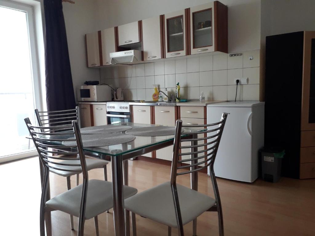 uma cozinha com uma mesa e cadeiras e um frigorífico em apartmán Peškova em Olomouc