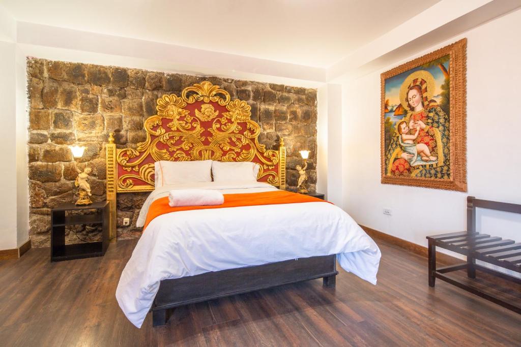 a bedroom with a king sized bed with a stone wall at Hotel Monasterio del Inka in Cusco