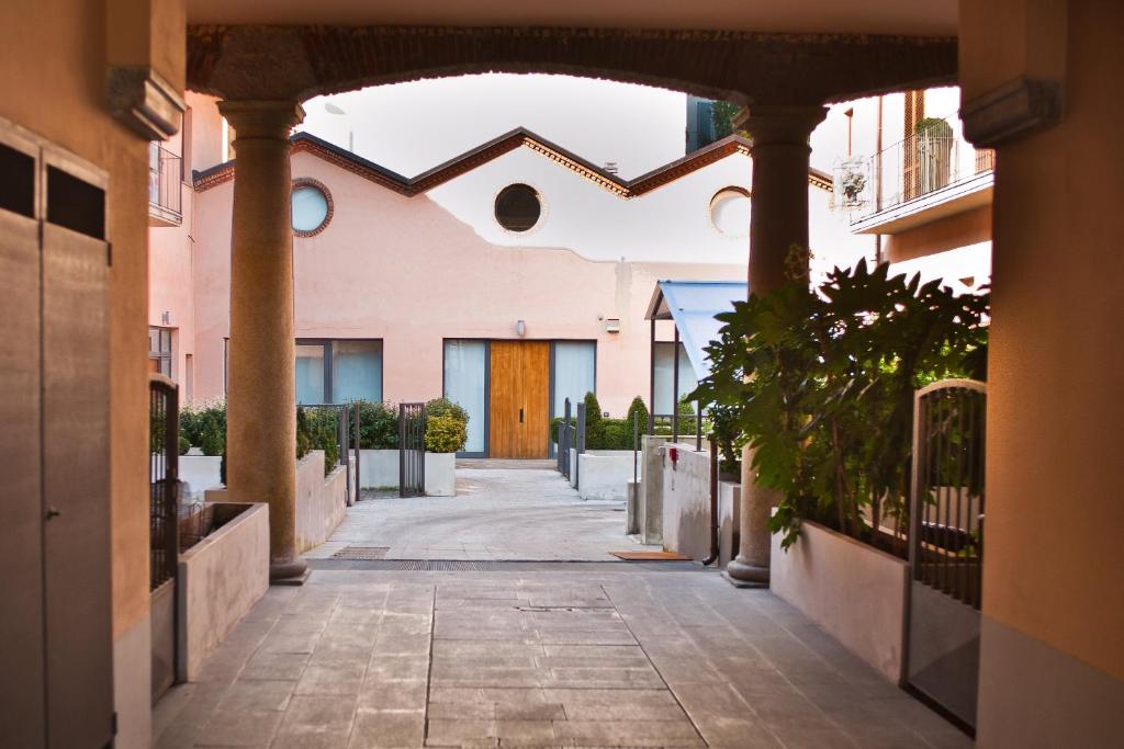 an alleyway leading to a building with a wooden door at Easy Milano - Rooms and Apartments Navigli in Milan