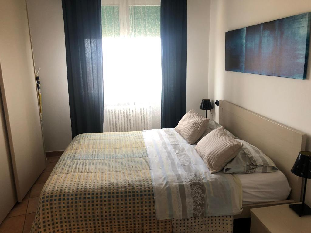um quarto com uma cama e uma janela grande em Apartment Verdiano em Parma