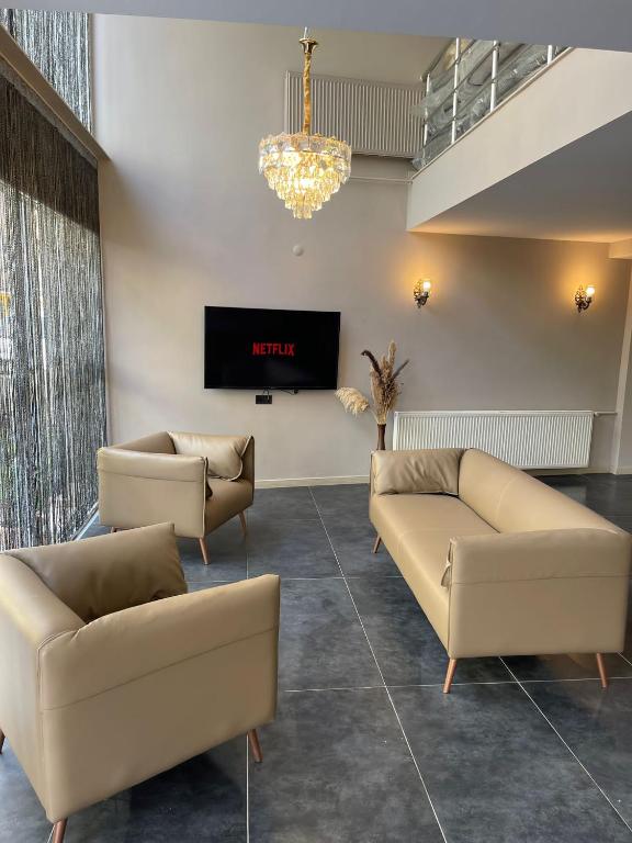 a living room with two couches and a tv at Grand Faik Hotel in Çeşme