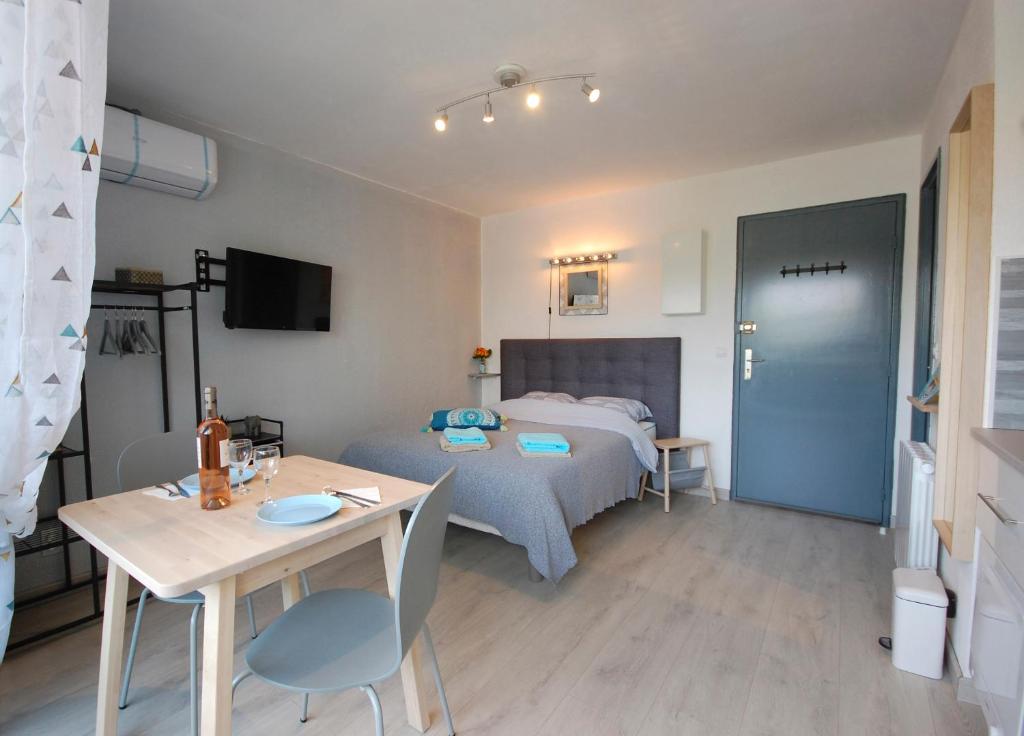 Cette petite chambre comprend un lit, une table et une table. dans l'établissement Saphir de Gruissan, à Gruissan