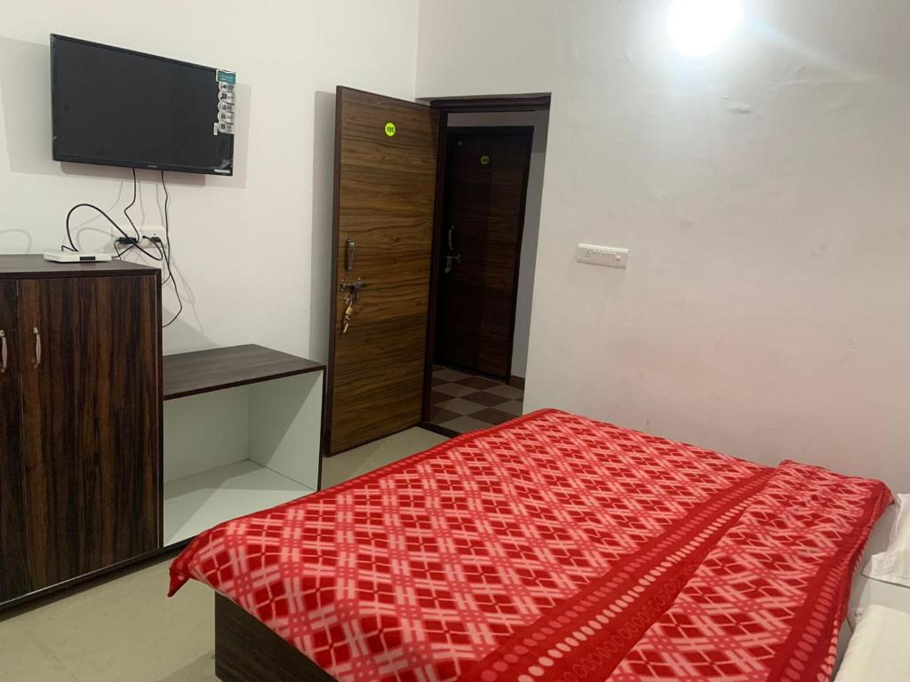 a bedroom with a bed and a flat screen tv at Saatvik Homestay in Katra