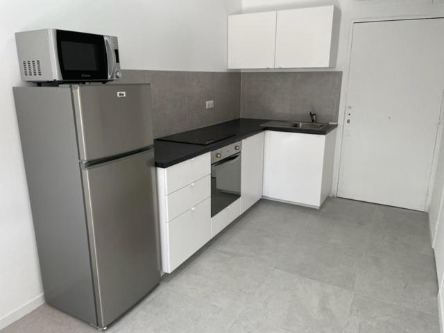 une petite cuisine avec un réfrigérateur et un micro-ondes dans l'établissement Appartement 30 m2, piscine et parking privé, à Mouans-Sartoux