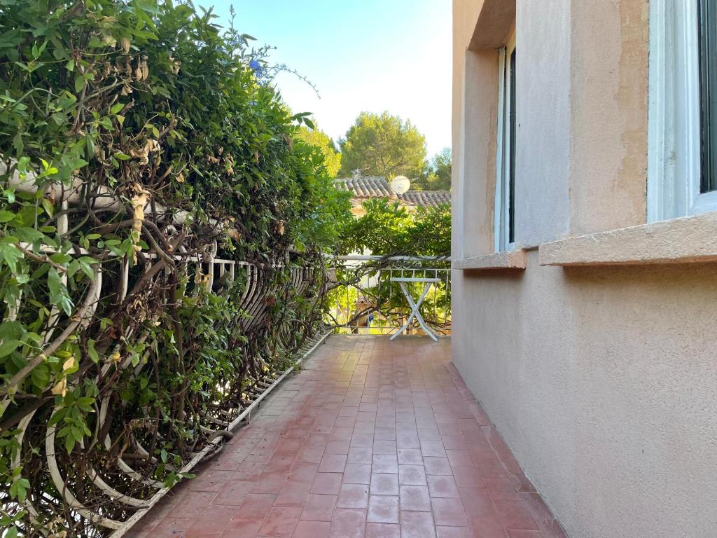 a brick walkway next to a building with a fence at Appartement spacieux et lumineux Calanques Sormiou in Marseille