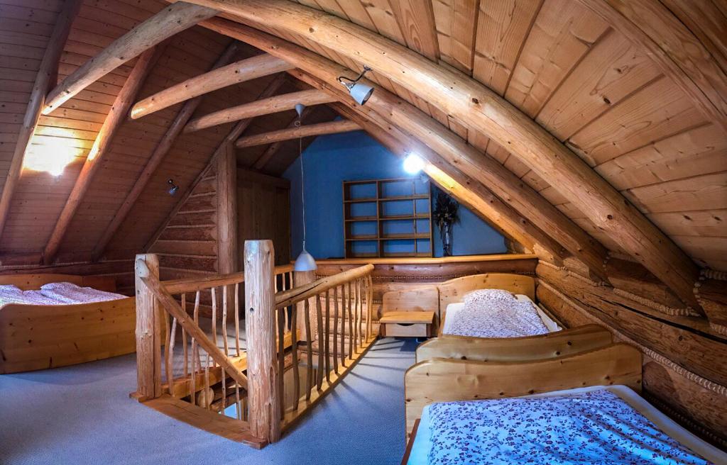 an attic room with two beds in a cabin at Domek na Skałce in Żabnica