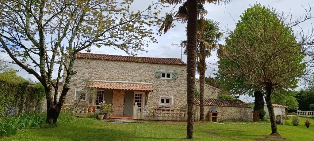 - une vue sur l'extérieur d'une maison en pierre avec des arbres dans l'établissement Gîte Maelga, à Cartelègue