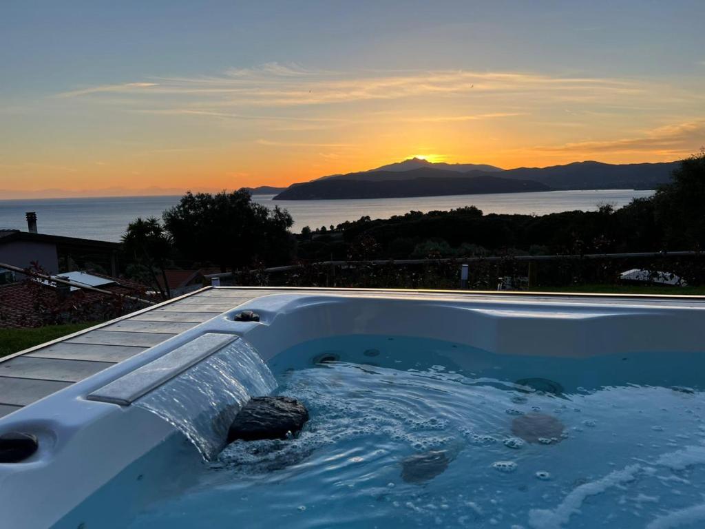 een hot tub met een waterpartij en een zonsondergang bij Villa Regina in Capoliveri