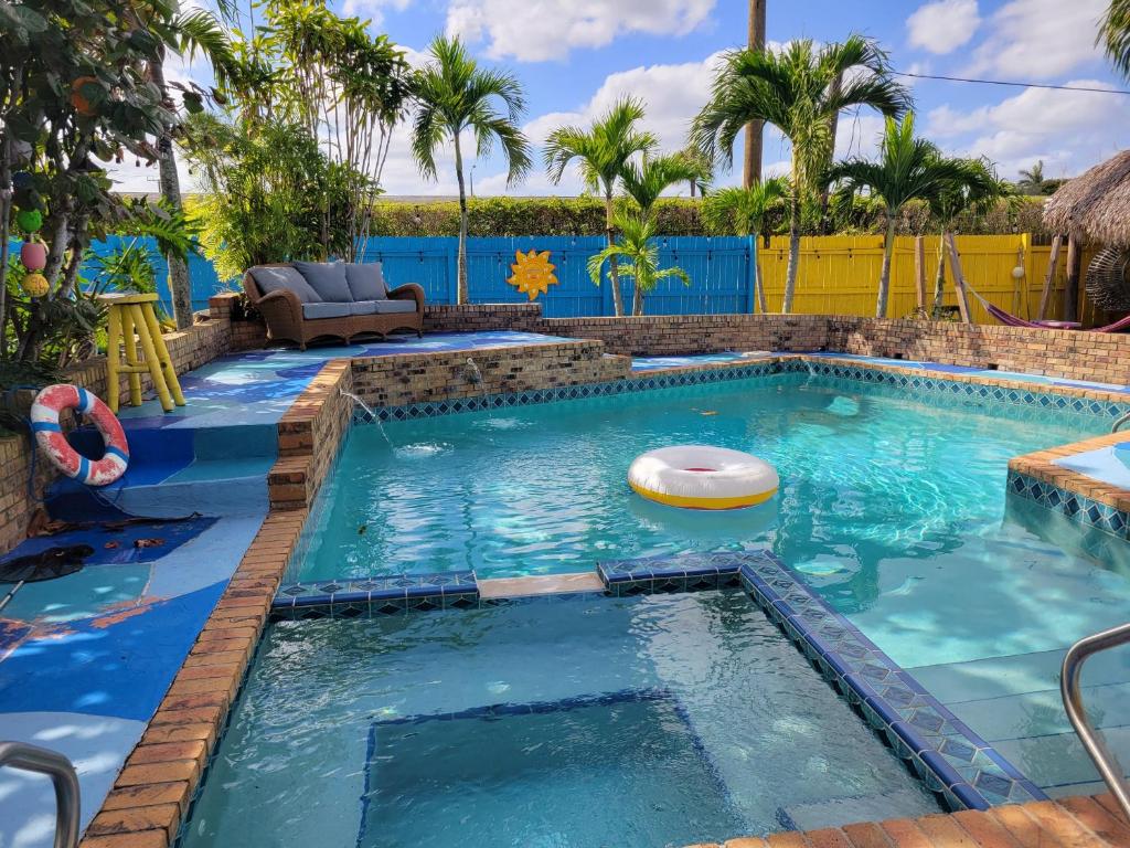 a swimming pool in a resort with a volley ball in the water at Susan and Ledif's Tropical Hideaway in Greenacres City