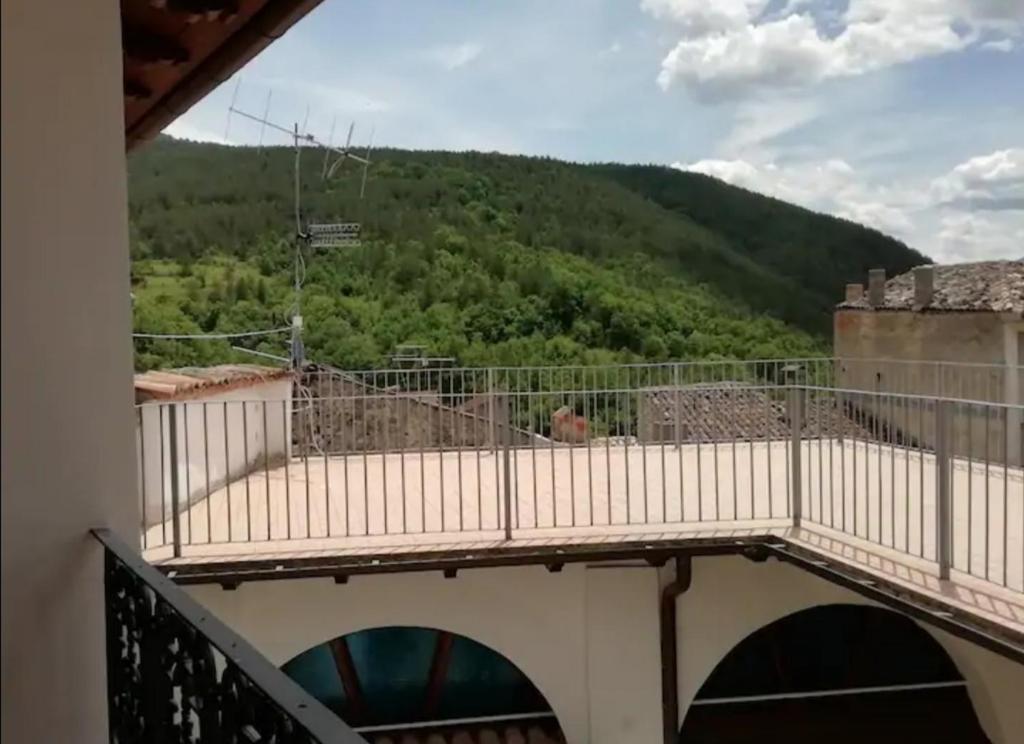 balcone di un edificio con vista sulle montagne di PIAZZETTA DEL FORNO GRAZIOSO BILOCALE ad ASSERGI ad Assergi