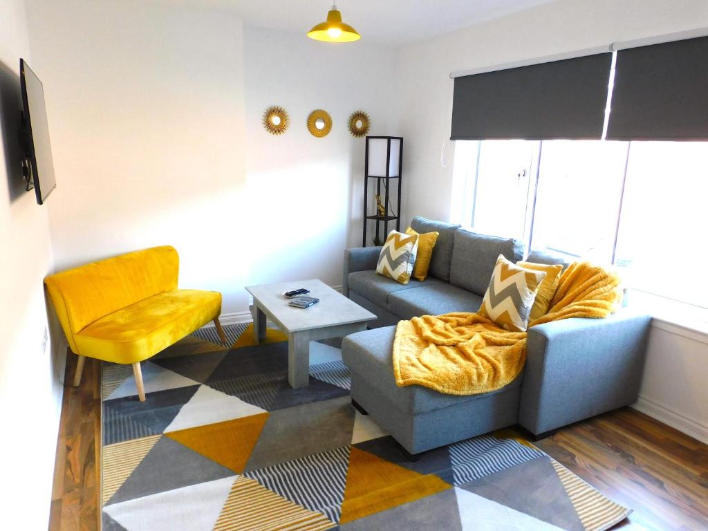 sala de estar con sofá y silla en Newly refurbished 2 bedroom apartment close to station and local amenities en Hamilton