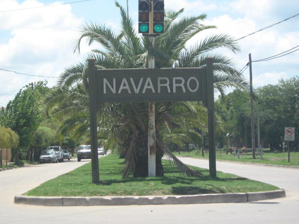 a street sign with a traffic light in front of a palm tree at Aquí Tampoco in Navarro