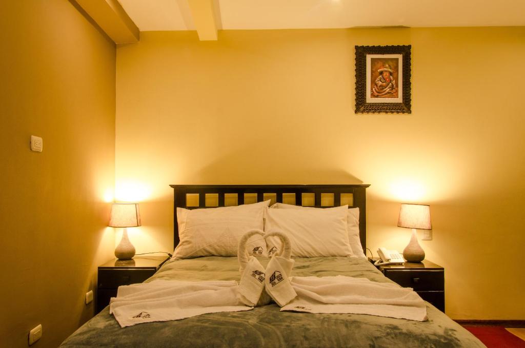 una camera da letto con un letto con un paio di scarpe sopra di Cusco Bed and Breakfast a Cuzco
