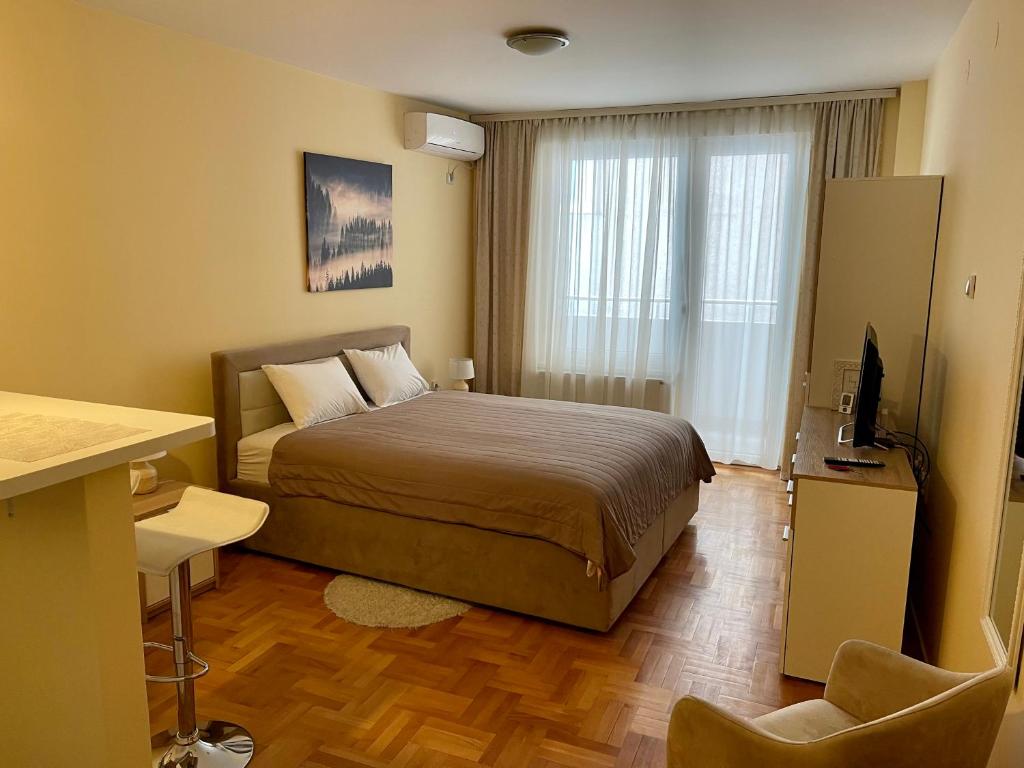 a bedroom with a bed and a television in it at Trident Apartments 2 in Niš