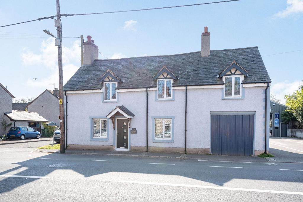 a white house with a garage on a street at The Old Nags Head in Ruthin