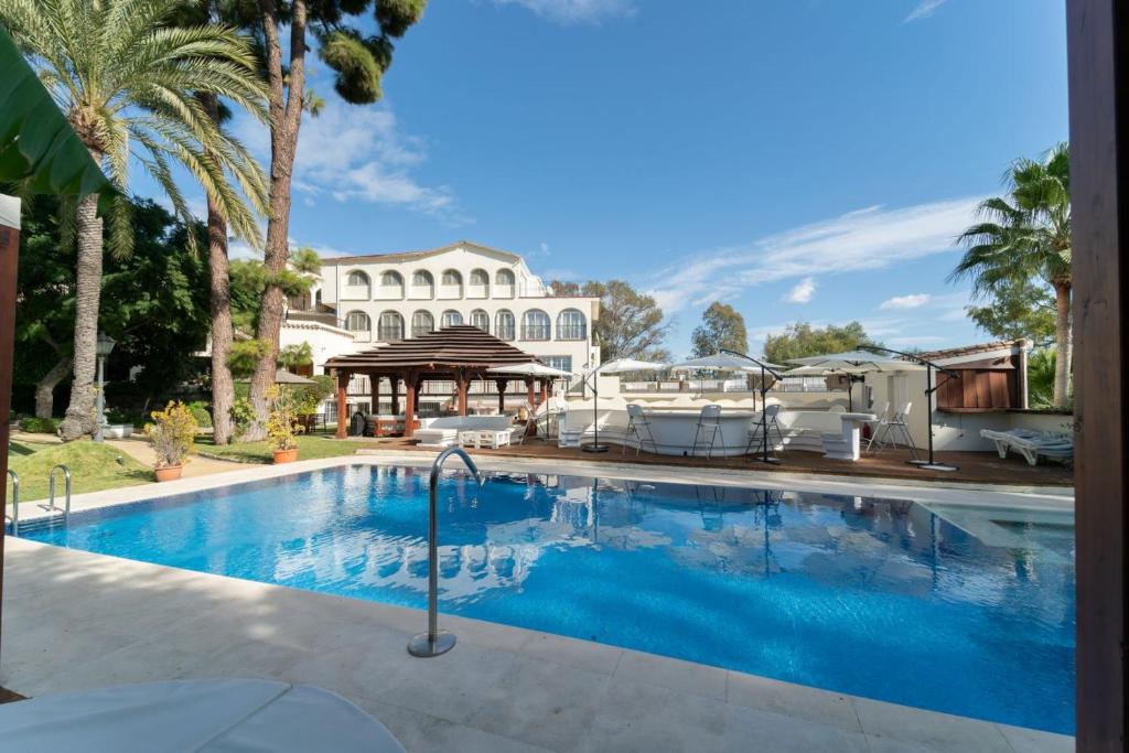 a swimming pool in front of a house at CASADELMAR Marbella in Marbella