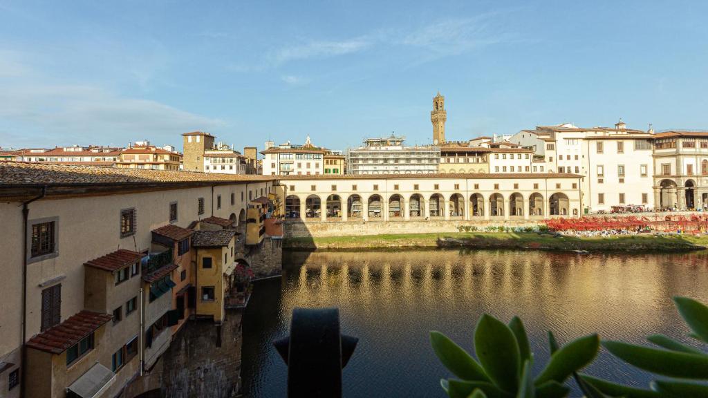 a view of a city with a river and buildings at Ponte Vecchio 3 bedroom apartment in Florence