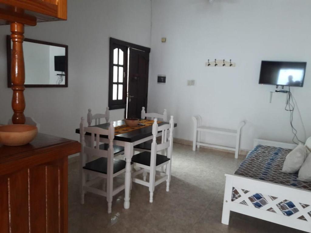 a dining room with a table and chairs and a television at Dptos Astrada in Goya