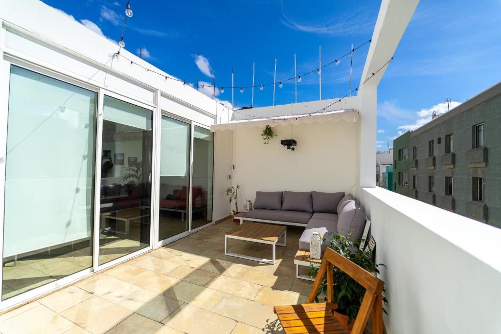 a living room with a couch on a balcony at Un Lugar House Canteras - Coliving in Las Palmas de Gran Canaria