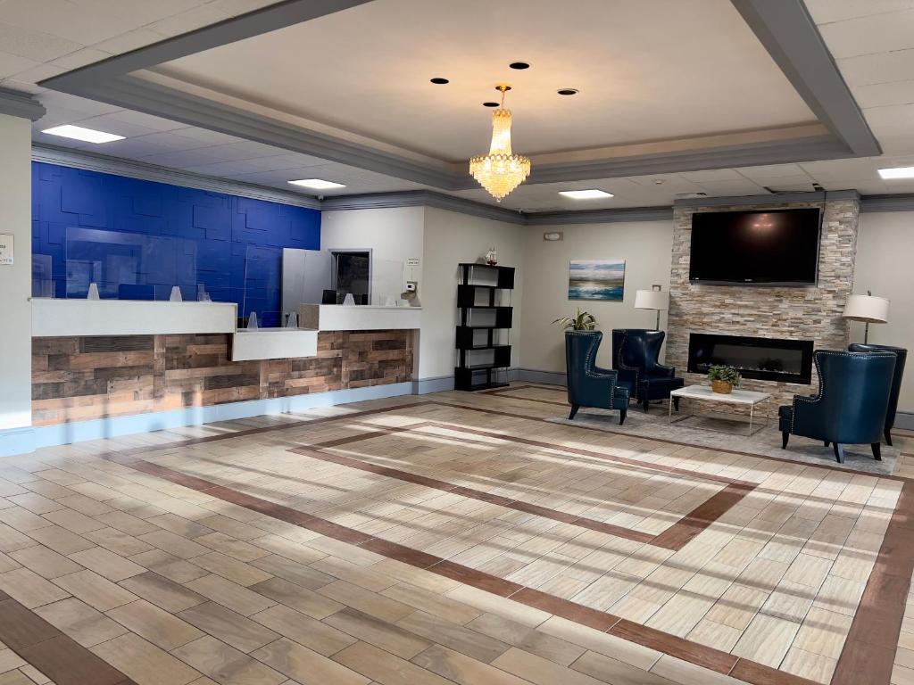 a lobby with a fireplace and a tv on the wall at Bradley Inn in Windsor Locks