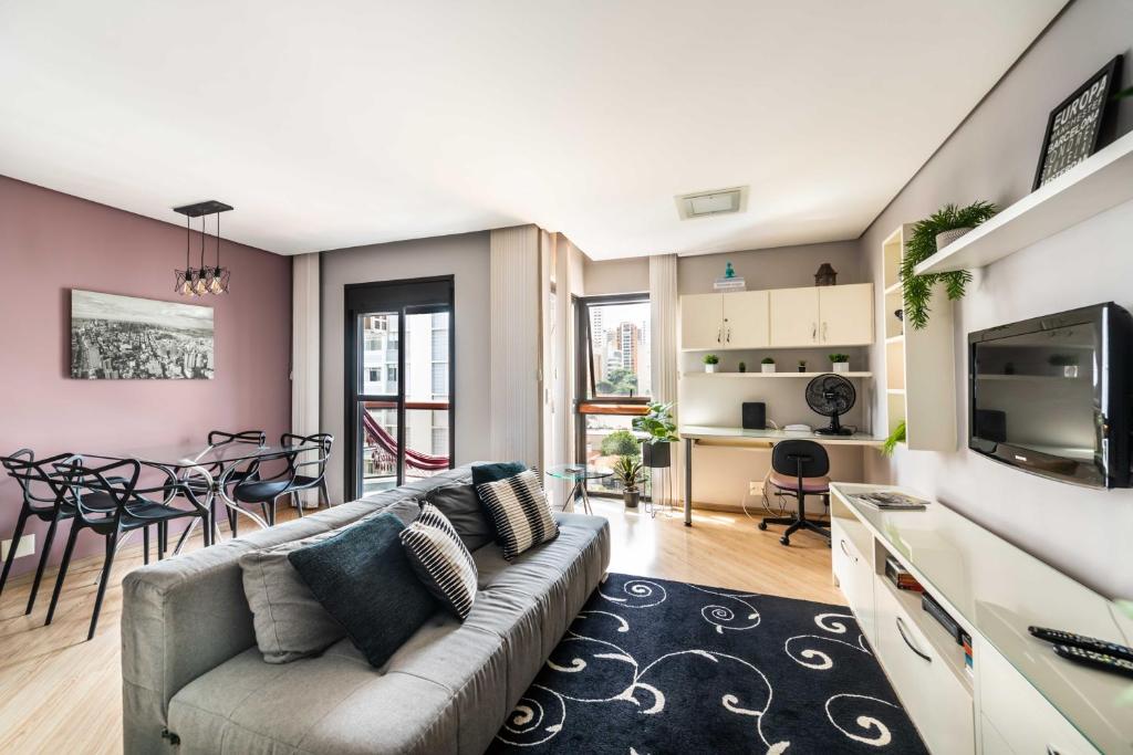 sala de estar con sofá y comedor en Apartamento Jardins Boutique, en São Paulo