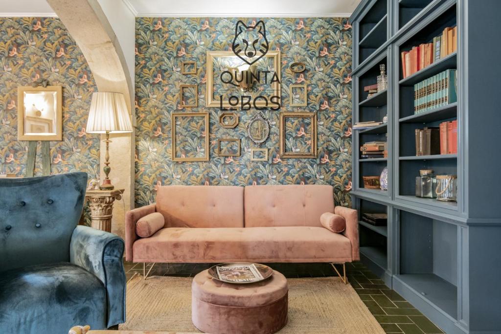 a living room with a couch and a table and bookshelves at Quinta dos Lobos Boutique Hotel - Nature Experience in Sintra