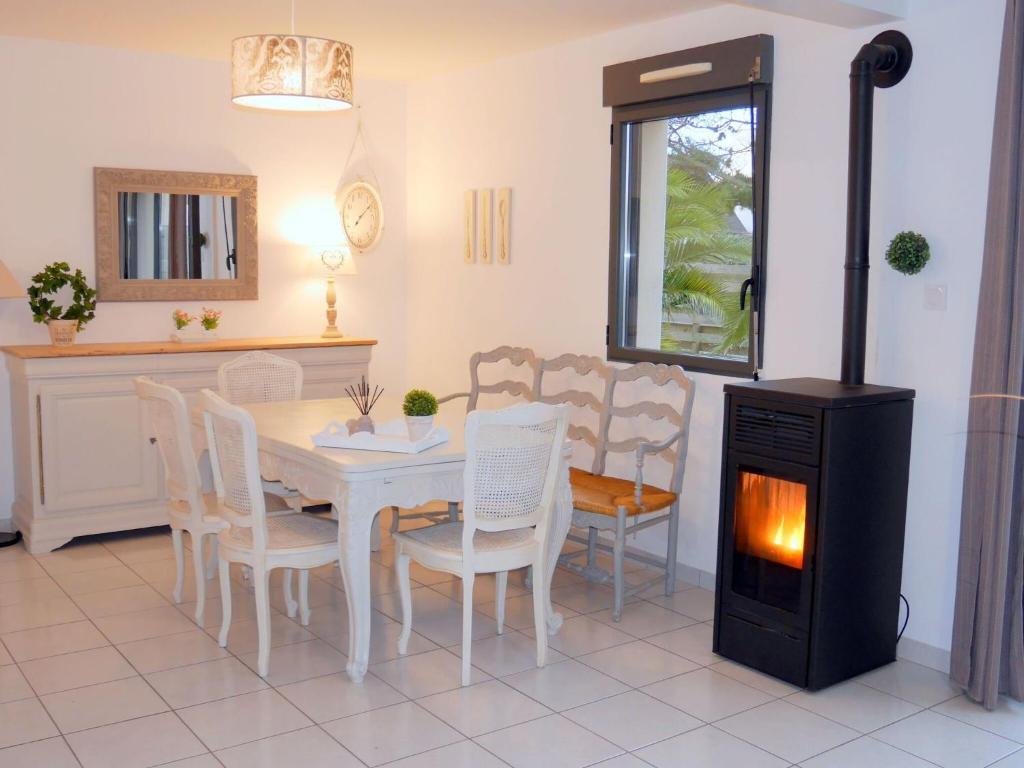 a dining room with a table and chairs and a stove at Beachfront holiday home, Guisseny in Guissény