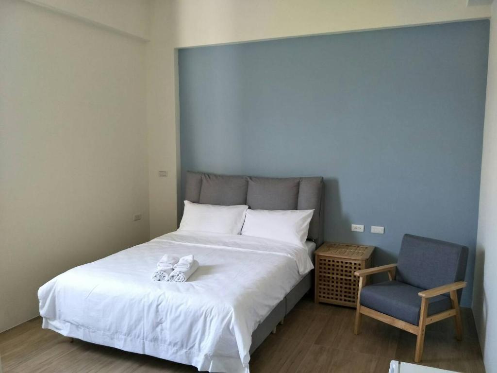 1 dormitorio con 1 cama y 1 silla azul en Good moment B&B, en Huxi