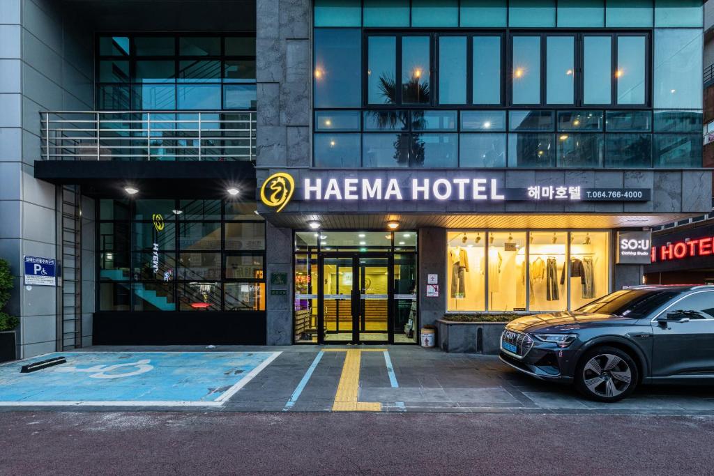 濟州的住宿－Hotel Haema，停在一个山羊酒店前的汽车