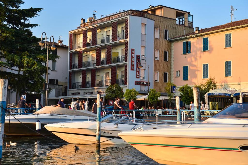 a group of boats docked in a harbor with buildings at AMBRA HOTEL - The only central lakeside hotel in Iseo in Iseo