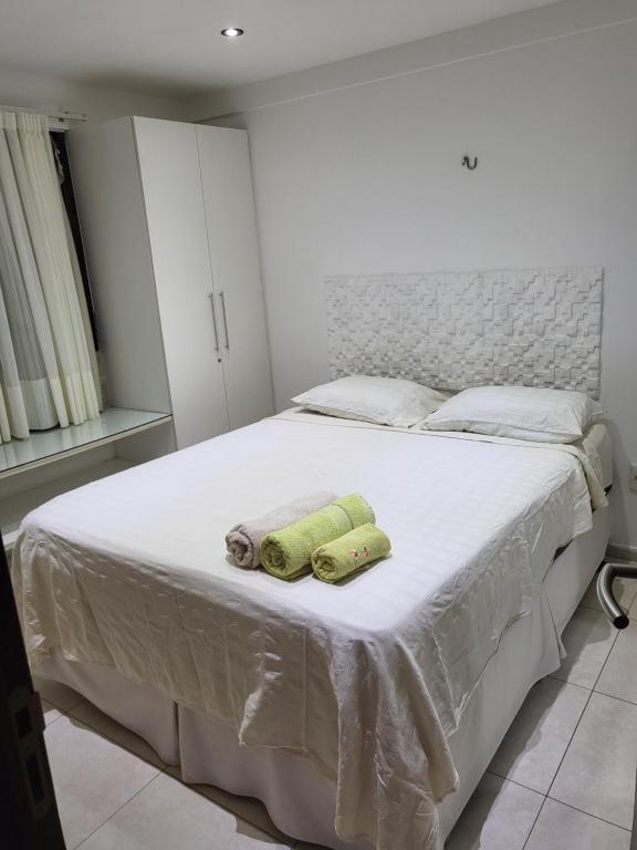 una camera da letto con un letto con due asciugamani sopra di Apartamento a beira mar a João Pessoa