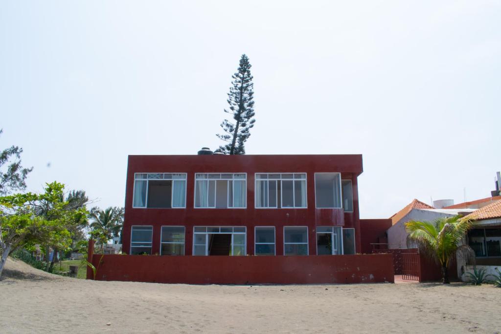 a red building with a tree on top of it at Casa Roja, Tecolutla (frente al mar) in Tecolutla