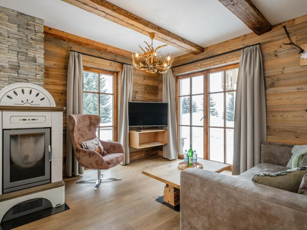 een woonkamer met een bank en een televisie bij Chalet Paul in Katschberghöhe