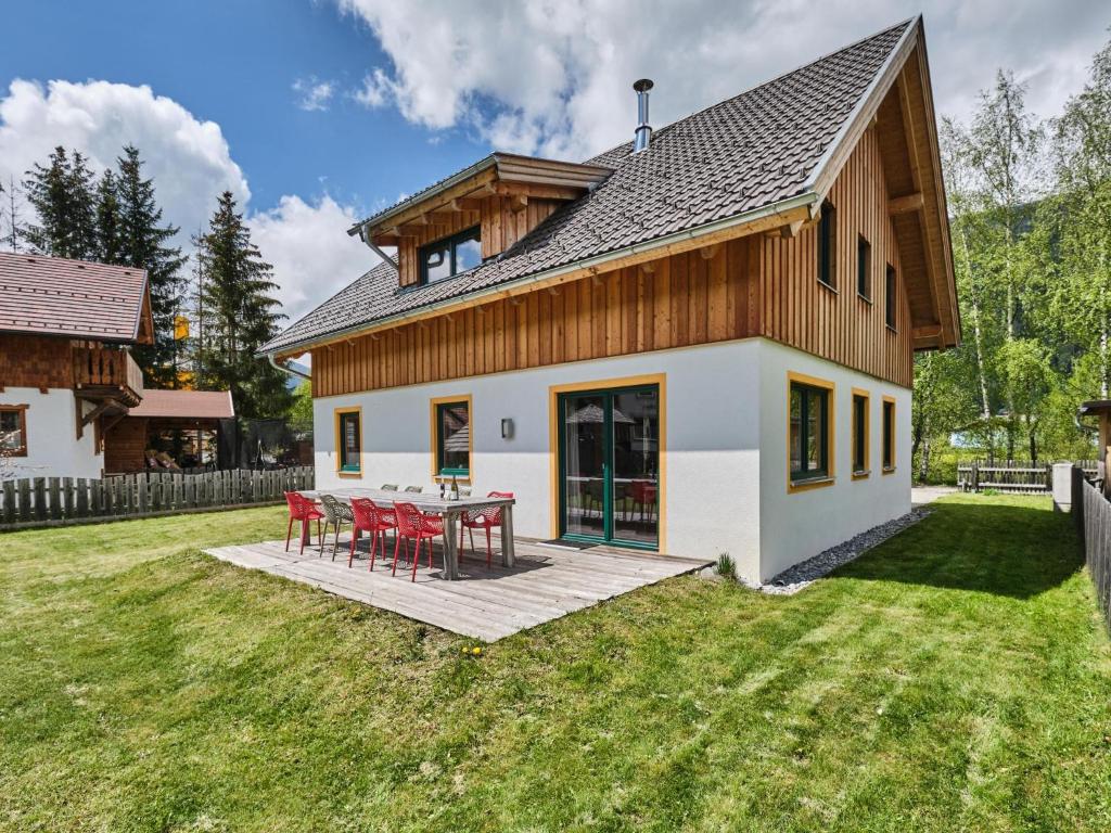 ein Haus mit einem Tisch und Stühlen im Hof in der Unterkunft Murtal Chalet in Sankt Michael im Lungau